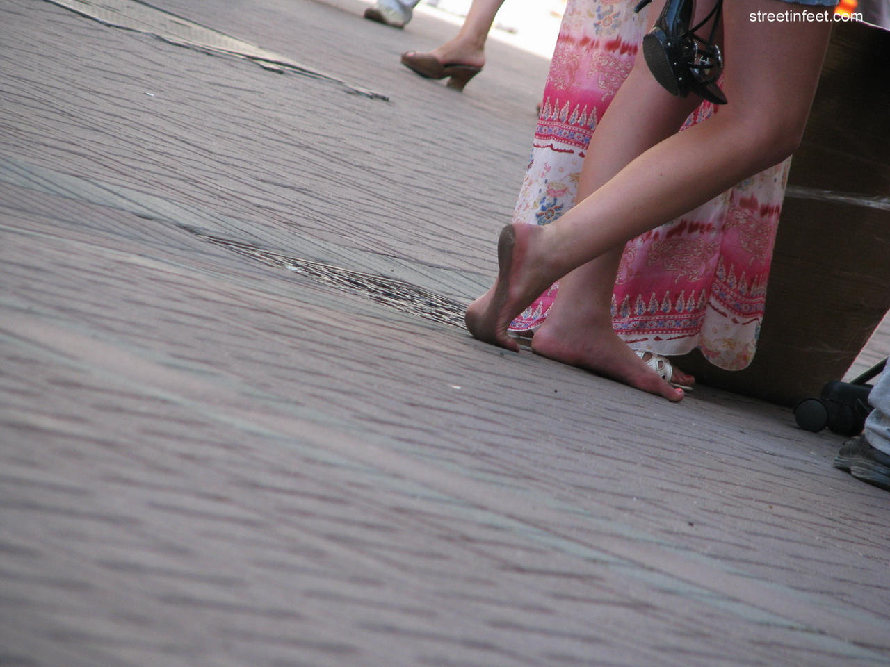 Barefoot lady walking in a arbat street with dirty soles 